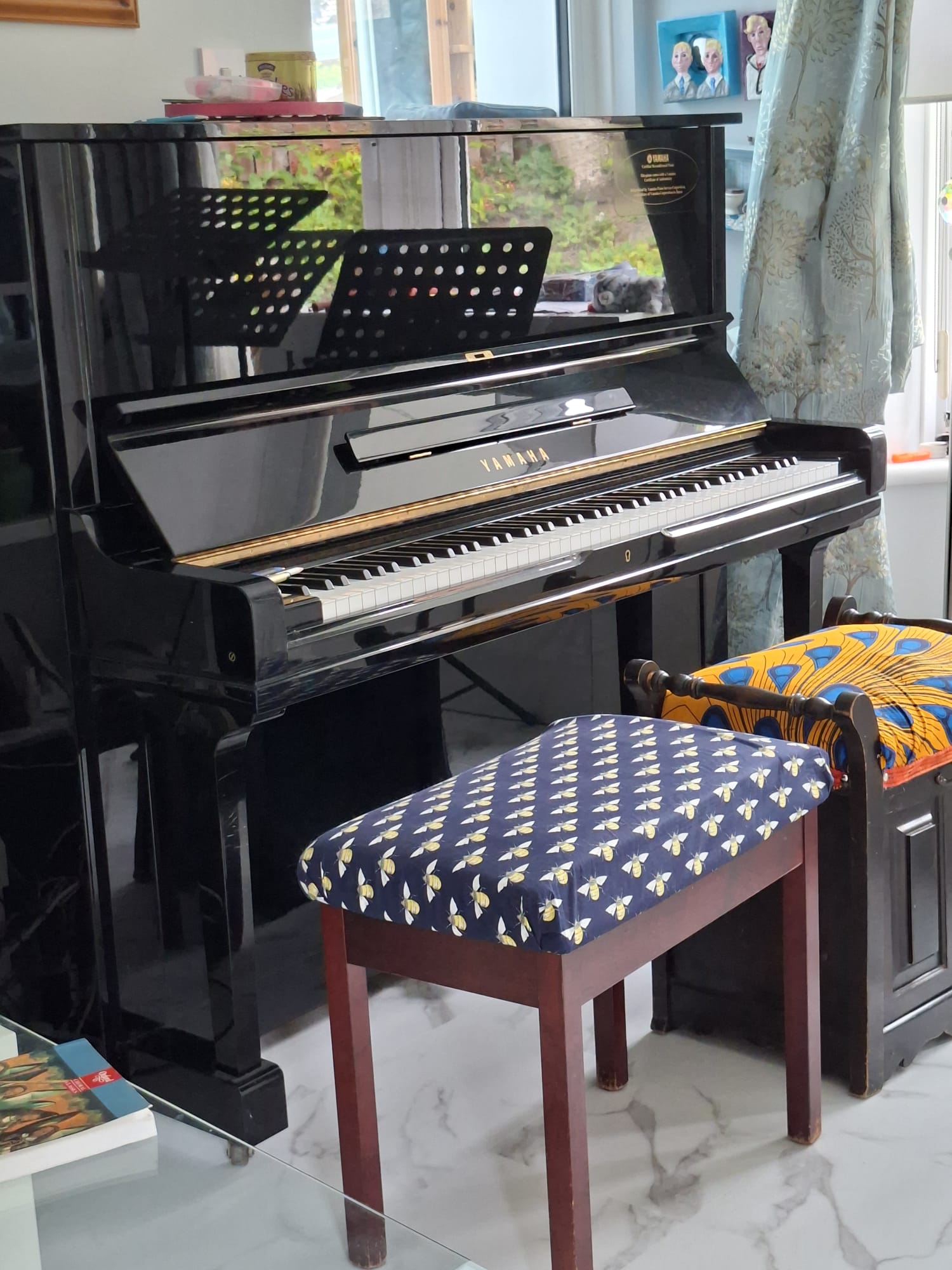 Black Yamaha upright piano with two piano stools